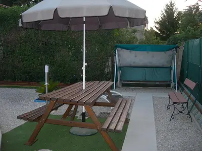 a picnic table with an umbrella and a bench at studio 66 in Caumont-sur-Durance