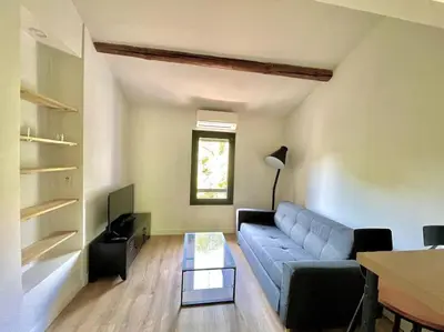 a living room with a blue couch and a table at Ravissant appartement à 5min du centre ville d'Aix in Aix-en-Provence