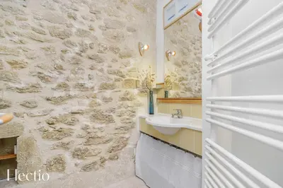 a bathroom with a sink and a stone wall at Mas du Rocher I Electio in Puget
