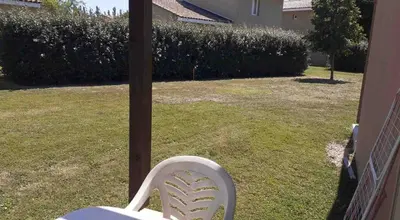 a white chair sitting on top of a yard at Belle Maisonette dans Residence 3* avec piscine partagée in Saint-Saturnin-lès-Avignon