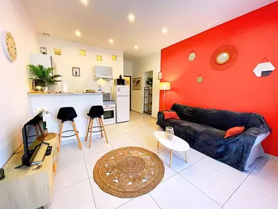 a living room with a couch and a red wall at Carré Rouge*Gare Sncf*Fibre Wifi in Miramas