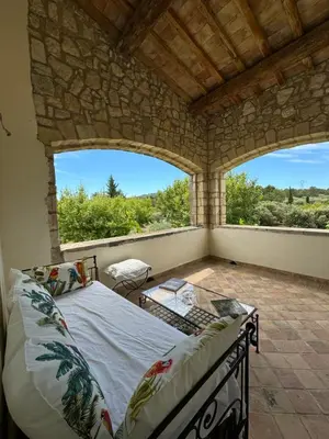 a bedroom with a bed and a large window at Chambre d'hôte au cœur de la Provence Eygalieres in Eygalières