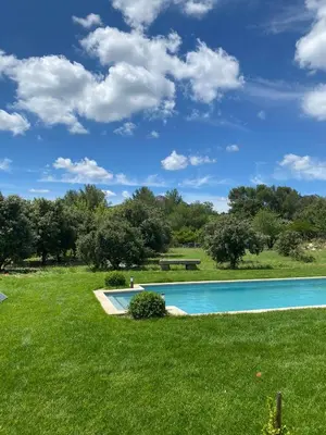 a swimming pool in the middle of a grass field at Chambre d'hôte au cœur de la Provence Eygalieres in Eygalières