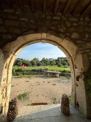 an archway in a stone building with a picnic table at Chambre d'hôte au cœur de la Provence Eygalieres in Eygalières