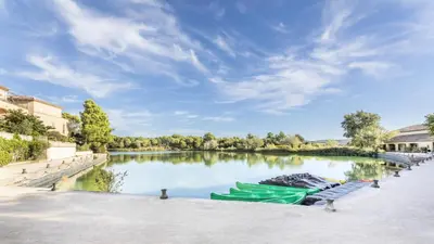 two green boats are docked on a river at Village Pont Royal en Provence - maeva Home - Maison climatisée 4 pièces 6 personnes - Sélection MAE-7054 in Mallemort