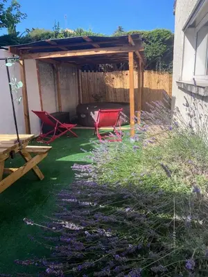 a garden with red chairs and a pergola at Appartement Velleron-4 personnes in Velleron