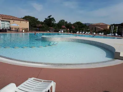 a large swimming pool with a chair and people in it at Maison conviviale à Aubignan avec piscine partagée in Aubignan