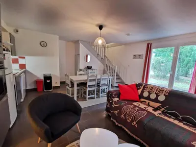a living room with a couch and a dining room at Maison conviviale à Aubignan avec piscine partagée in Aubignan