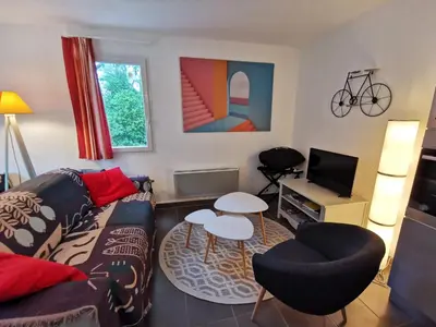 a living room with a couch and a tv at Maison conviviale à Aubignan avec piscine partagée in Aubignan