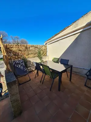 a patio with a table and chairs and a fence at Les oliviers in Ansouis