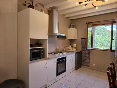 a kitchen with white cabinets and a stove top oven at Les oliviers in Ansouis