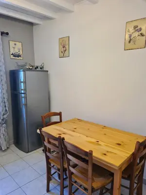 a kitchen with a wooden table and a refrigerator at Les oliviers in Ansouis