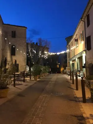 an empty street with tables and buildings at night at L’OBSERVATOIRE in Saint-Michel-lʼObservatoire