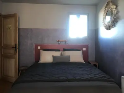a bedroom with a bed with a window and a mirror at L’OBSERVATOIRE in Saint-Michel-lʼObservatoire