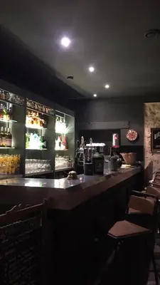 a bar in a restaurant with a counter and chairs at L’OBSERVATOIRE in Saint-Michel-lʼObservatoire