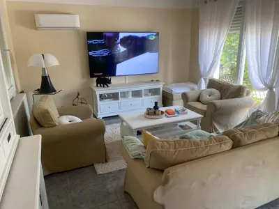 a living room with couches and a flat screen tv at Villa des palmiers in Saint-Saturnin-lès-Avignon