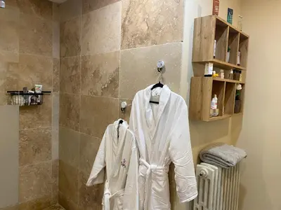 a white robe is hanging in a bathroom at Villa des palmiers in Saint-Saturnin-lès-Avignon
