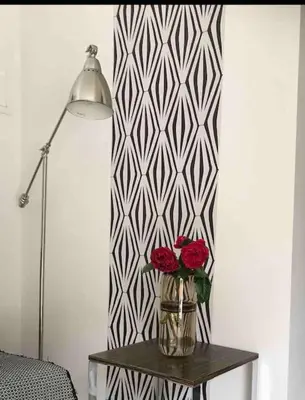 a vase with two roses on a table next to a lamp at Gîte de charme La Manola in Rognes