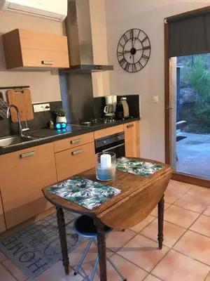 a kitchen with a wooden table and a sink at Gîte de charme La Manola in Rognes