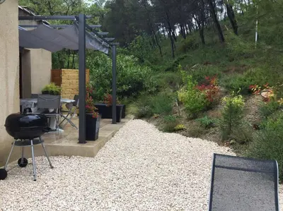 a grill in a yard next to a garden at Gîte de charme La Manola in Rognes