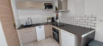 a small kitchen with white cabinets and a sink at MyLuberon-Appartement au pied du Luberon in Lauris