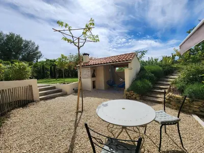 a patio with a table and chairs in front of a house at MyLuberon-Appartement au pied du Luberon in Lauris