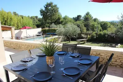 a blue table with plates and wine glasses on it at Escapade en Provence, Gîte à Lagnes, Luberon, Vaucluse in Lagnes