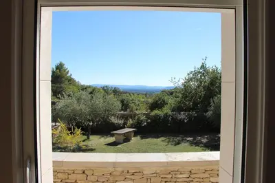 a window with a view of a park with a bench at Escapade en Provence, Gîte à Lagnes, Luberon, Vaucluse in Lagnes