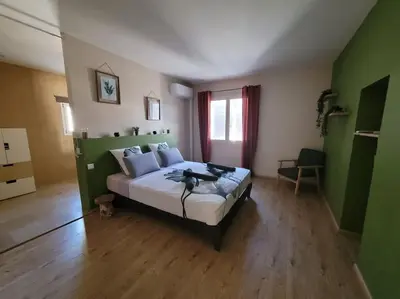 a bedroom with a large bed in a green room at Escapade en Provence, Gîte à Lagnes, Luberon, Vaucluse in Lagnes