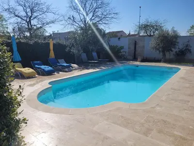 a swimming pool with a sprinkler in a yard at maisonnette avec piscine la picholine in Châteaurenard