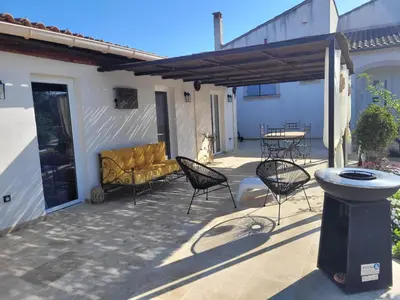 a patio with chairs and a table and a bench at maisonnette avec piscine la picholine in Châteaurenard