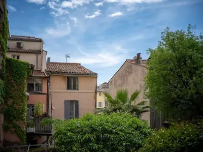 a man and a child walking down a street with buildings at Studio tout équipé au coeur de Aix en Provence in Aix-en-Provence