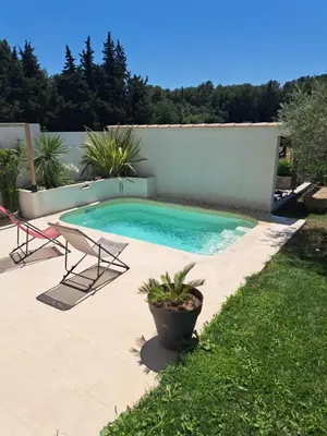 a swimming pool with two chairs and a table at Maison avec piscine en Provence in Saint-Cannat