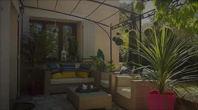 a patio with a couch and some potted plants at A l'Orée du Pin in Puyricard