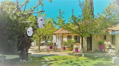 a house with two white bags hanging from a tree at A l'Orée du Pin in Puyricard