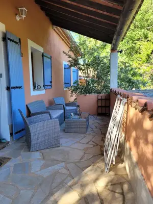 a patio with couches and chairs on a house at Location saisonnière villa Lauris in Lauris