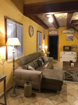 a living room with a couch and a table at Location saisonnière villa Lauris in Lauris