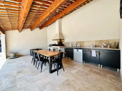 a large kitchen with a wooden table and chairs at Villa Saint Jean En Provence in Châteaurenard