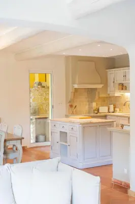 a kitchen with white cabinets and a white couch at Maison à 2 pas du Village D'ansouis à 30 Minutes D'aix-en-provence in Ansouis