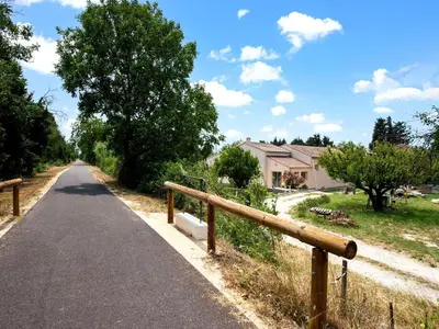 a road with a fence next to a house at Holiday Home in Vaucluse near Mont Ventoux in Pernes-les-Fontaines