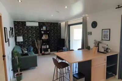 a kitchen and living room with a table and chairs at Gîte Aux Bons Voisins in Gordes