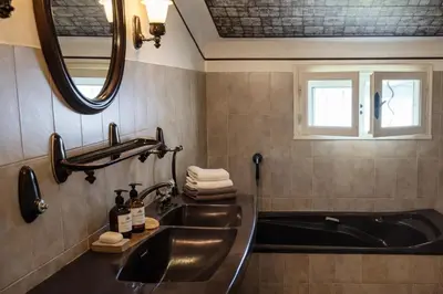 a bathroom with a tub and a sink and a mirror at Gîte de campagne Clos Beau Soleil in Caumont-sur-Durance