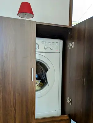 a washing machine in a kitchen with a red light at Gîte de campagne Clos Beau Soleil in Caumont-sur-Durance
