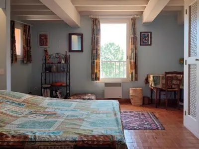 a bedroom with a bed and a large window at Holiday Home La Tourelle des Ocres by Interhome in Roussillon