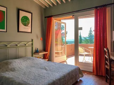 a bedroom with a bed and a door to a balcony at Holiday Home La Tourelle des Ocres by Interhome in Roussillon
