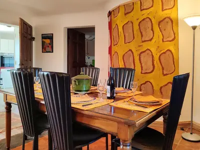a dining room table with chairs and a yellow wall at Holiday Home La Tourelle des Ocres by Interhome in Roussillon