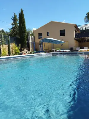 a large swimming pool in front of a house at Villa lavandin in Apt