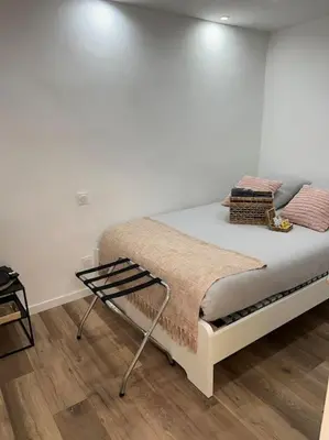 a bed in a room with a white wall at Chambre Mignet in Aix-en-Provence