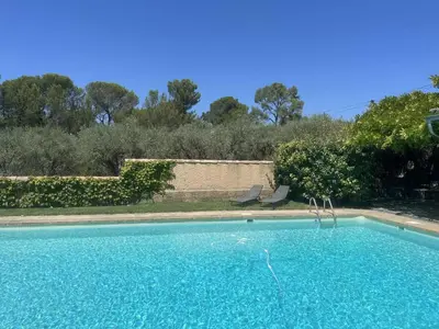 a swimming pool with blue water in a yard at Agréable maison de 65 m2 avec grande piscine in Aix-en-Provence