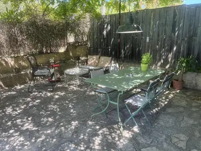 a patio with a table and chairs and a fence at Agréable maison de 65 m2 avec grande piscine in Aix-en-Provence